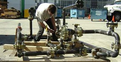 A man working on pipes in an industrial setting.